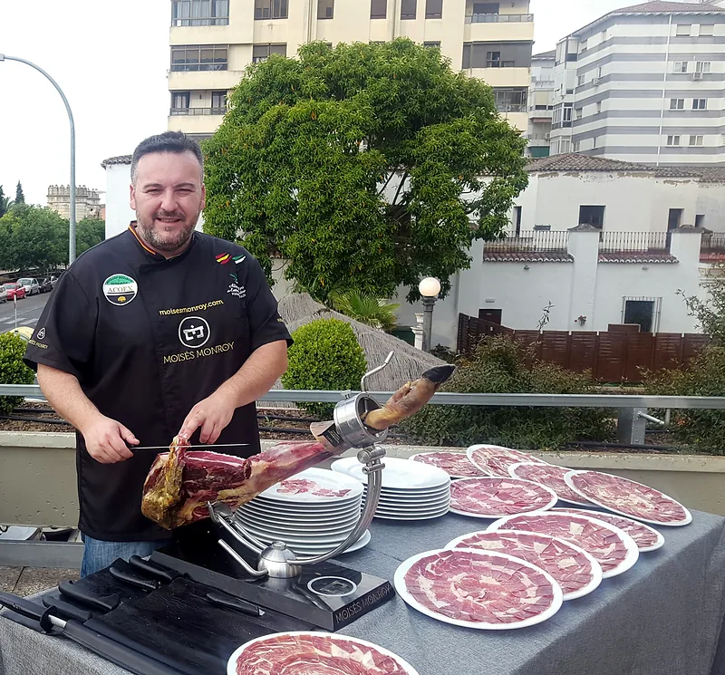Moisés Monroy con platos de jamón emplatado para un evento
