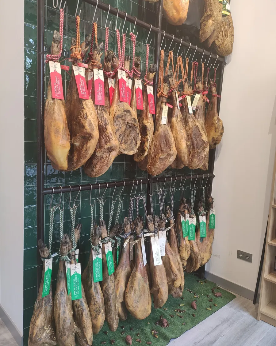 Pared de jamones de bellota y de cebo de campo en la tienda